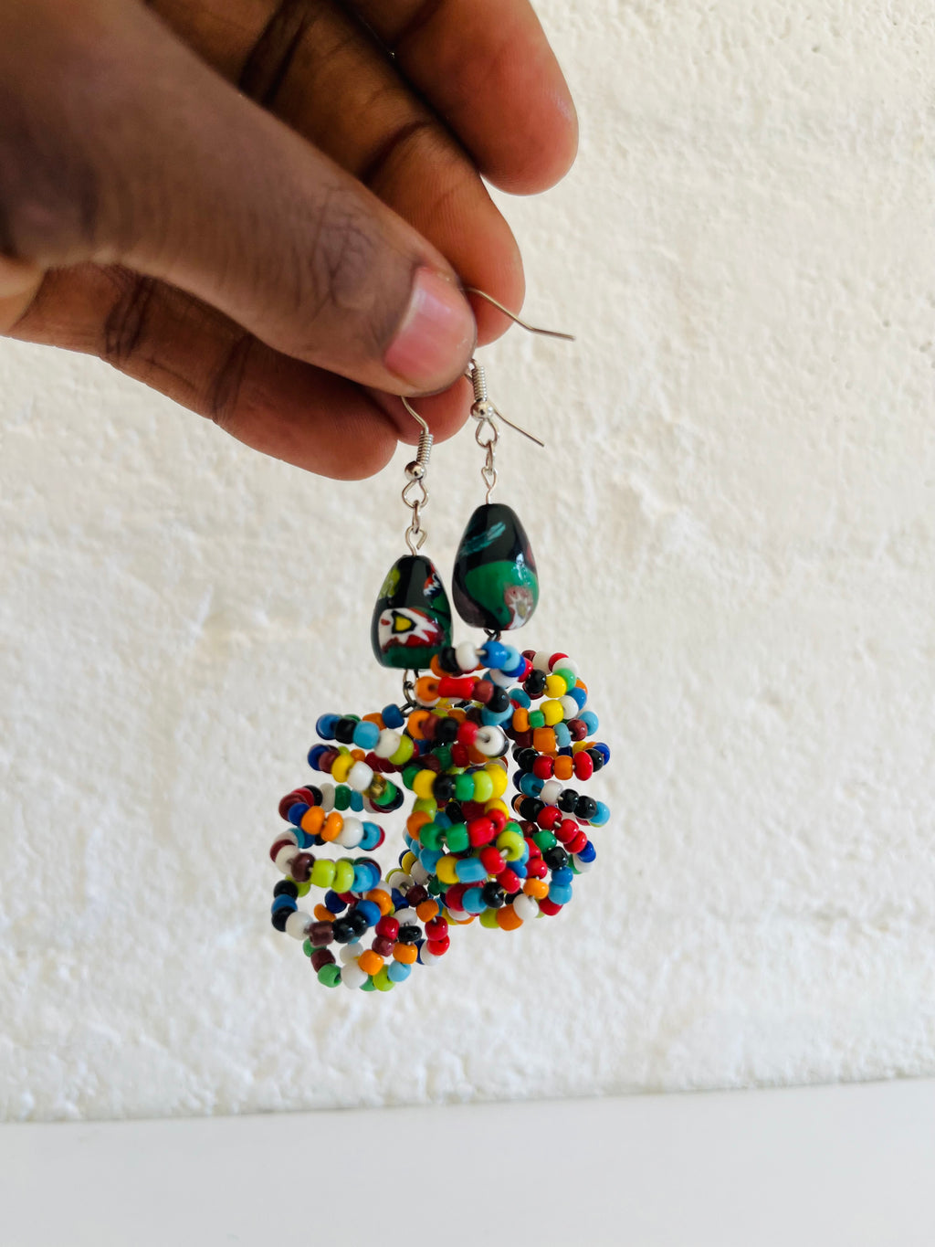 Beaded earrings featuring mixed-colour beads arranged in a handmade pattern
